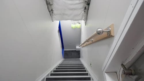 Captain coming from ship engine room and walking up stairs towards camera