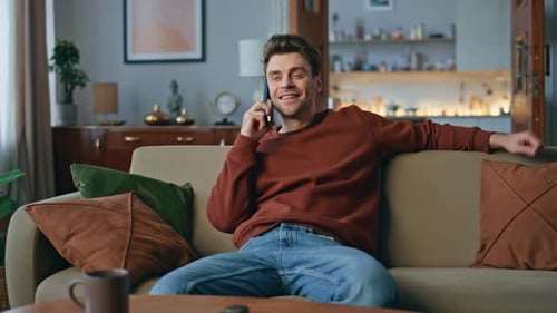Man Chatting on Phone while Relaxing on Couch