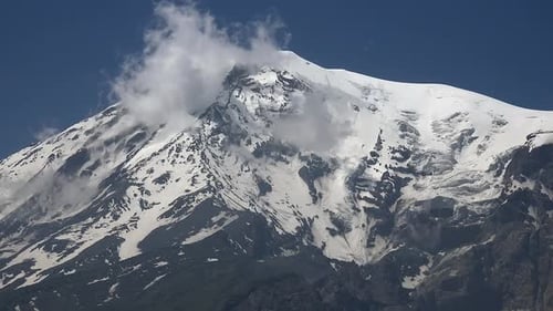 Mount Ararat snow covered volcanic peak rising on eastern Anatolia border with alpine landscape.
