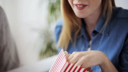 Woman Eating Popcorn with Friend Indoors