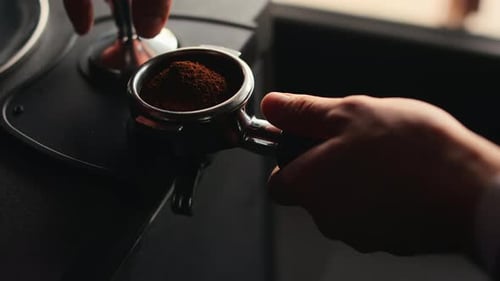 Coffee Grounds Being Tamped in a Portafilter