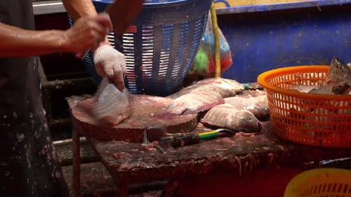 Marktangestellter beim Putzen und Entkernen eines Fisches