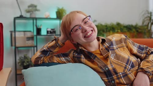Woman Smiling and Relaxing on a Couch