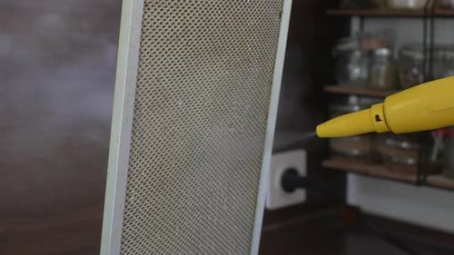 Closeup Hands of Unrecognizable Man Cleaning Cleaning Mesh Filter of Cooker Hood Using Steam Cleaner