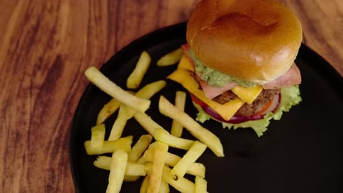 Delicious burger and fries on a black plate