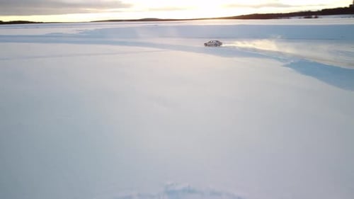 Sport Car Drifting on Frozen Lake in Finland during golden hour – Aerial Winter Landscape with a fro
