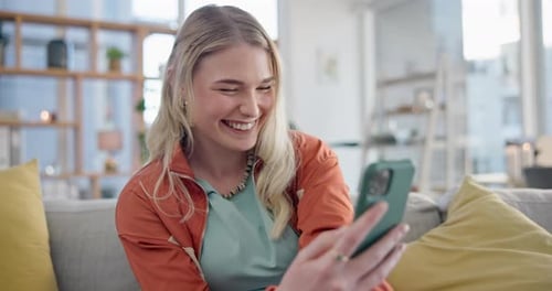 Smiling Woman Using Smartphone While Sitting on Couch
