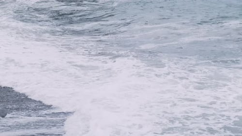 Stormy sea waves on the shore. Breaking wave line in the sea with foamy white texture
