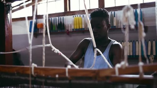 Man, floor, thread loom and fashion production at clothing factory, manufacturing and craftsmanship
