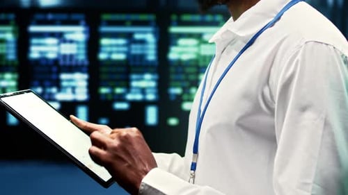 African American Engineer Inspecting Server Rigs Inside Data Center