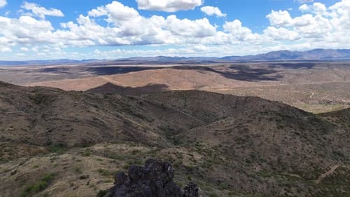Aerial view of mountains and desert under sunlit sky, United States.