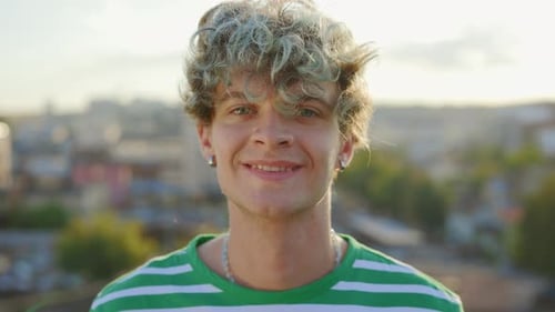 Gesichtsporträt einer attraktiven lächelnden talentierten Tänzerin, die auf einem Dach steht und vor der Kamera posiert