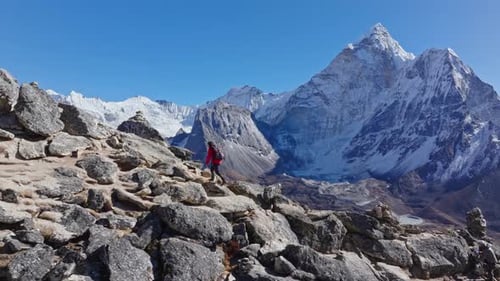 Mountaineer Navigates Rocky Ridge Wearing Red Jacket Prayer Flags Fluttering Mount Everest Peaks