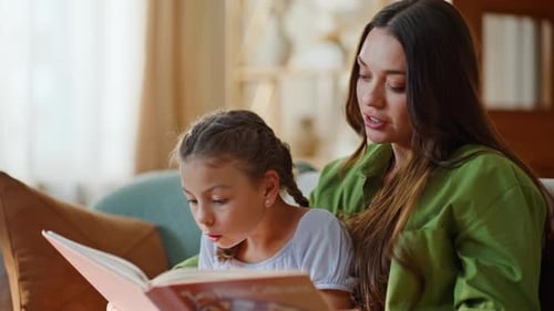 Mother and Daughter Reading a Book Together Indoors