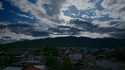 Zeitraffer der Wolken, die sich am dunkelblauen Himmel über der Stadt und den Hügeln bewegen