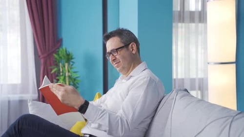 Man Relaxing on Couch Reading a Book