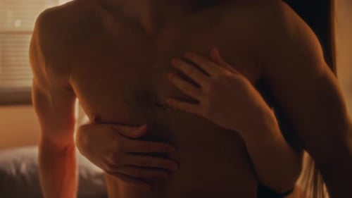 Shirtless Man Embraced by Woman in Golden Light