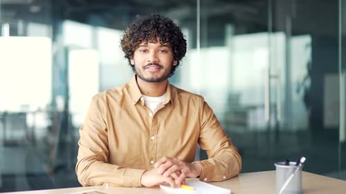 Webcam view. Young employee watching video call training looking at the camera sitting at workplace