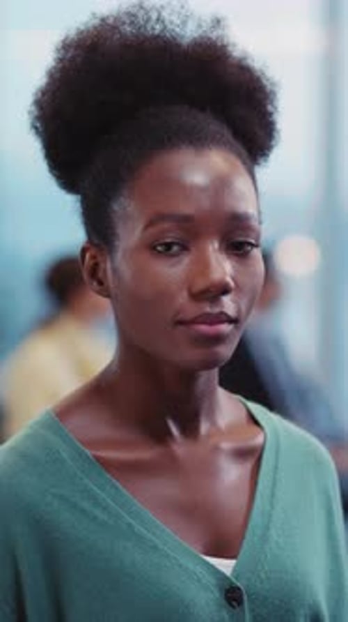 A Woman in a Green Cardigan Smiles Warmly Creating an Inviting Vibe