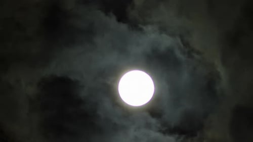 Full Moon behind Moving Clouds at Night