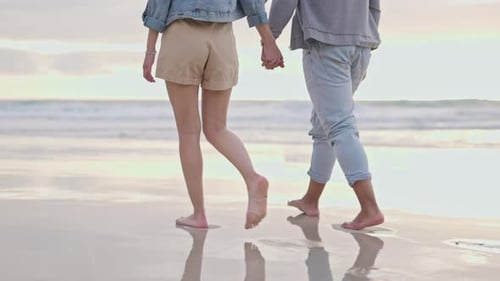 Legs walking, holding hands and a couple at the beach for holiday freedom, love and romance