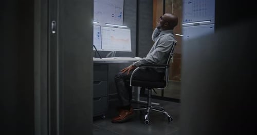 Happy Stock Broker Monitoring Exchange Market Charts Talking on Phone