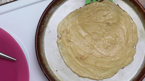 A Woman Prepares Waffle Cones. Flips The Pancake On The Pan. Close Up Shot From Above.