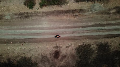 Foto aérea de una persona que conducía una motocicleta en una carretera rural por la noche