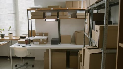 Bureau d'employé parmi les rayonnages avec des colis au bureau de livraison de courrier