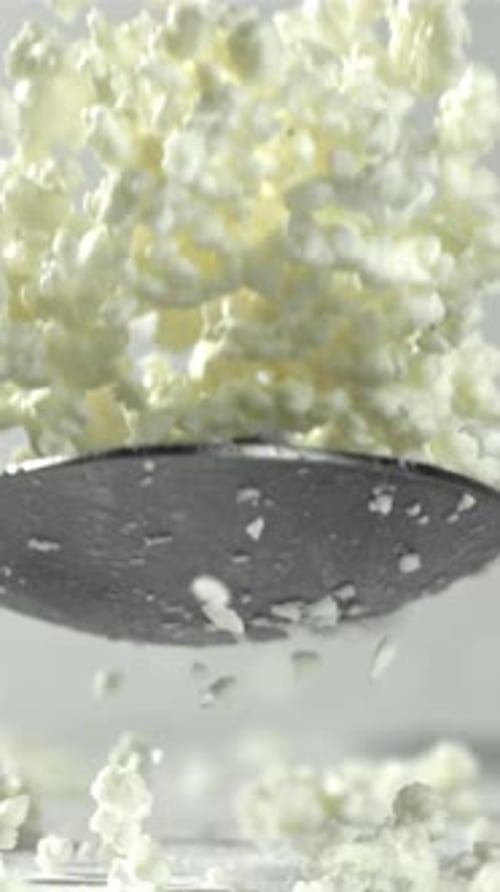 A Spoonful of Fresh Cottage Cheese Falls on the Table Filmed on a Highspeed Camera at 1000 Fps