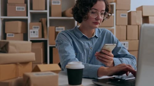 Woman Working at Desk with Laptop and Phone