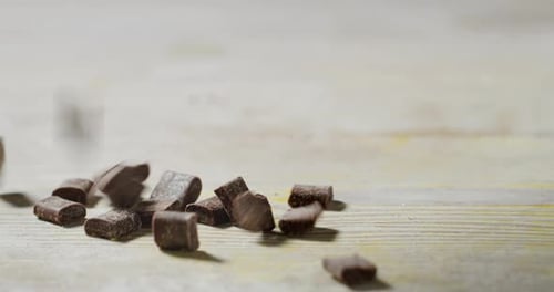Zeitlupe eines Kochs, der einige Schokoladenstückchen in den Teig gibt, um ein Dessert zuzubereiten. Konzepte von