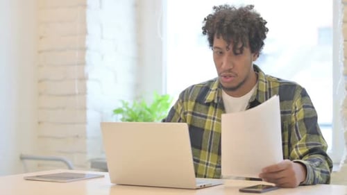 Young Man Celebrating Success at Laptop