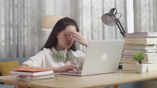 Stressed Asian Teenager Suffer From Headache Bad Vision Sight Problem While Use Laptop At Home Table