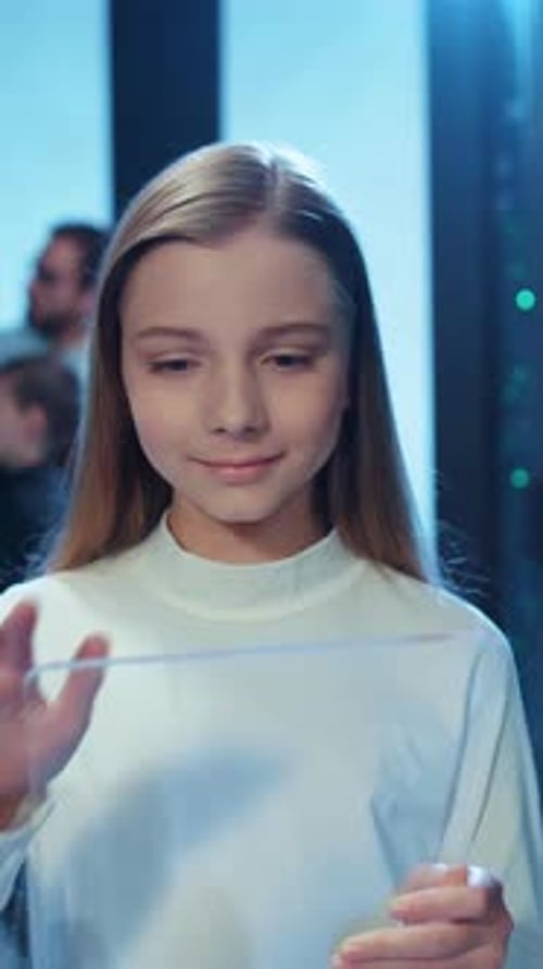 Young girl using a transparent digital tablet device