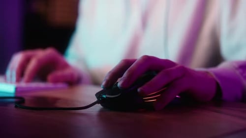 Detail of computer mouse used by gamer at night. Shot with RED helium camera in 8K.