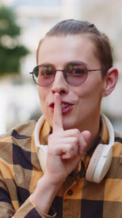 Young Man Presses Index Finger to Lips Making Silence Hush Gesture Sign Do Not Tells Gossip Secret