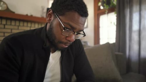 Black man glasses phone worried Steadicam shot