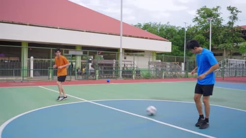 Asian two sportsman practicing football playing in the outdoors stadium.