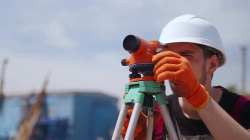 Construction Surveyor Using Leveling Instrument on Site