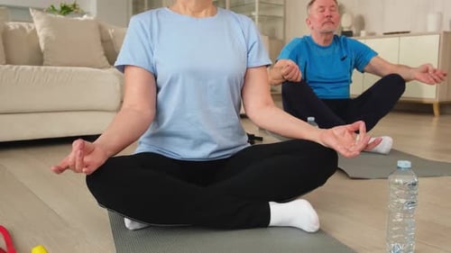 Couple Practicing Yoga Exercises in Living Room