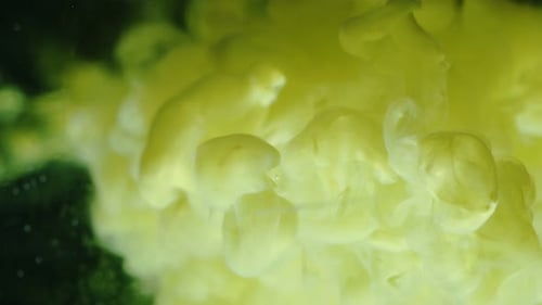 De l'encre jaune jaillit dans le réservoir d'eau noire.