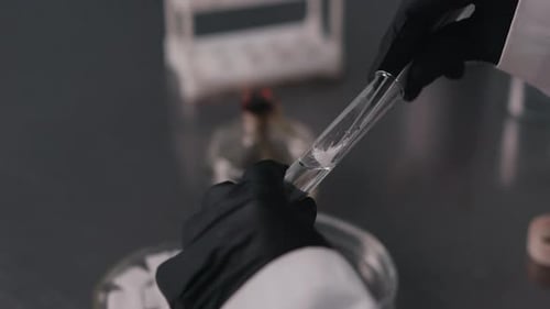Un technicien de laboratoire manipule un tube à essai pendant une analyse scientifique en gros plan