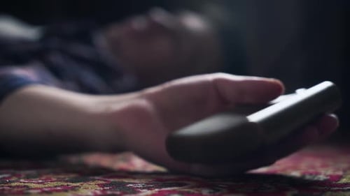 Adult Lying Down Holding Metal Flask