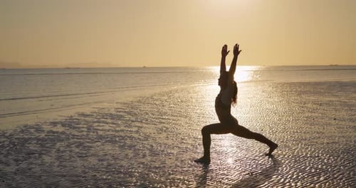 Silhouette of Flexible Female Presents Yoga Asana on Sea Beach at Sunrise