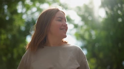 Woman Smiling Outdoors in Natural Light, Relaxing