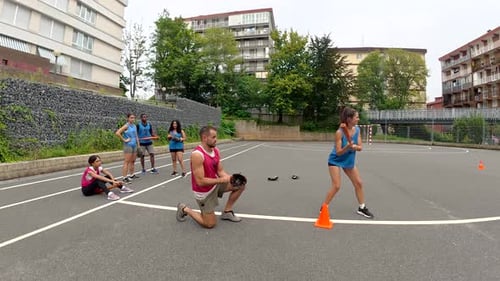 Female Baseball Player Practicing Swing with Coach on Outdoor Field