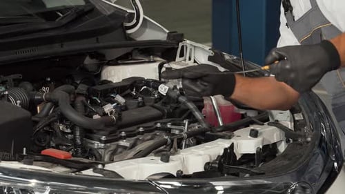 Skilled Mechanic Meticulously Checking Oil Level and Engine Components