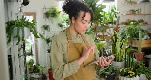 Woman Using Tablet in a Plant Store