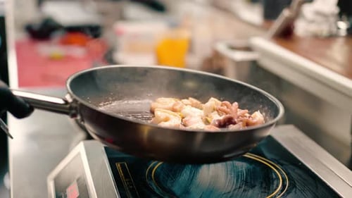 Professional kitchen in the hotel restaurant close-up seafood fried on a pan shrimp squid mussels